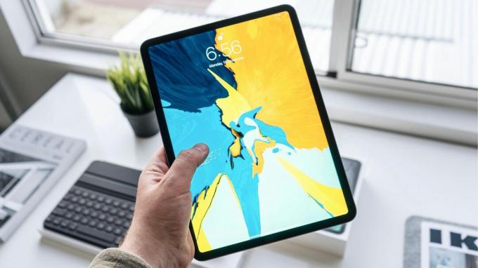 Държи iPad Pro с ярък тапет